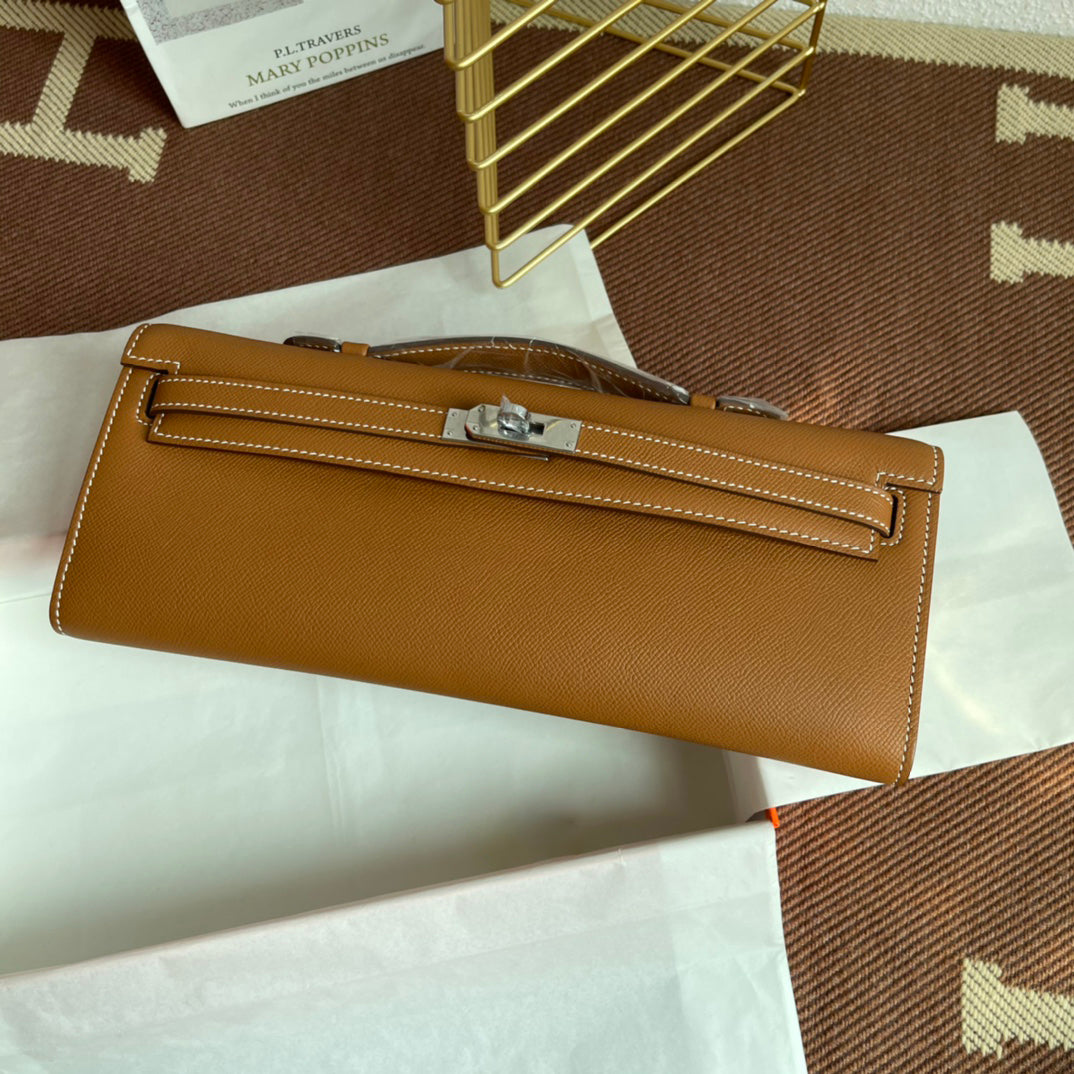 Warm Golden Tan Elongated Hand Clutch With Contrast Light Stitching And Polished Silver Twist-Lock Hardware