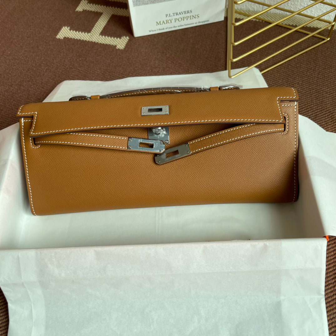 Warm Golden Tan Elongated Hand Clutch With Contrast Light Stitching And Polished Silver Twist-Lock Hardware