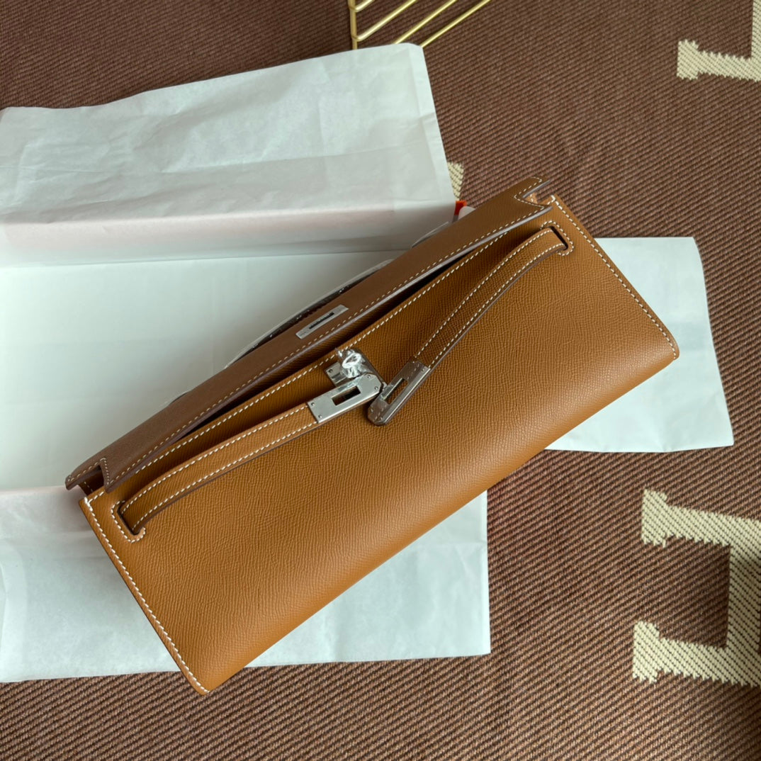 Warm Golden Tan Elongated Hand Clutch With Contrast Light Stitching And Polished Silver Twist-Lock Hardware